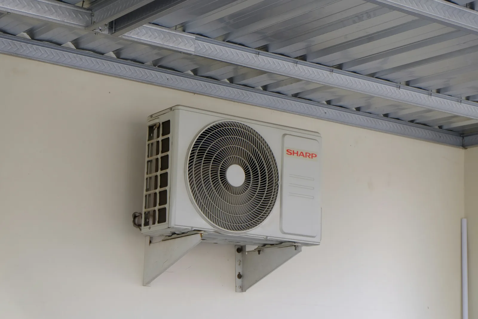 New outdoor air conditioning condenser mounted cleanly beside a building